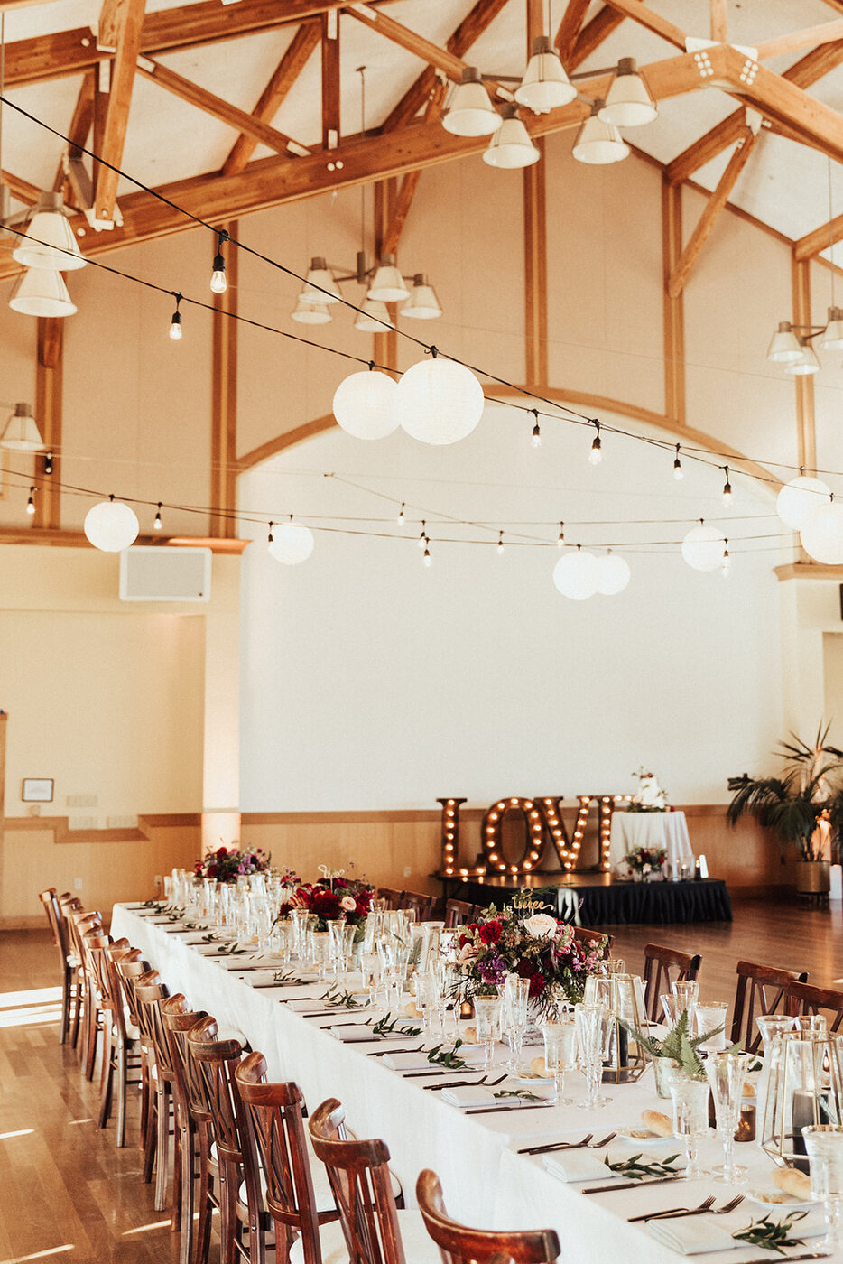 Long reception tables in a warm wood-beamed room